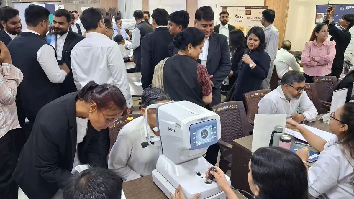 Patients at an Eye Mela camp, one being screened on the autorefractometer