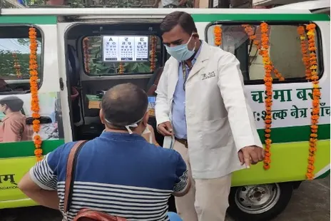 A doctor at the open door of the Chashma Bus, the Netram mobile eye-care van