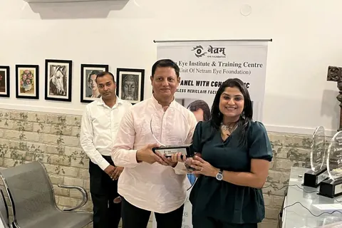 Dr. Anchal Gupta with colleagues holding a plaque